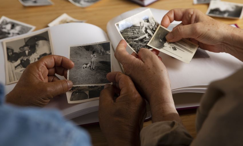 zwei Menschen schauen sich alte Schwarzweiß-Fotos an